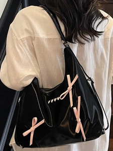 Borsa hobo nera lucida con fiocchi rosa e rivetti a cuore per un look trendy e dolce-cool