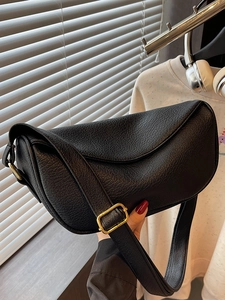 Sac fourre-tout noir minimaliste en cuir grainé avec boucle dorée et style moderne