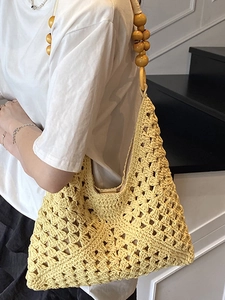 Bright yellow hand-woven crochet tote bag with large wooden bead shoulder strap