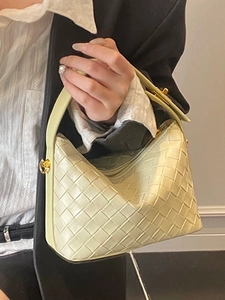 Pale yellow woven leather handbag with a textured Intrecciato pattern and top handle