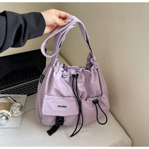 Detail view of the lavender nylon shoulder bag with adjustable buckle and drawstring closure