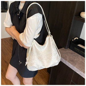 Detail of minimalist cream white hobo tote bag with intricate floral lace texture overlay