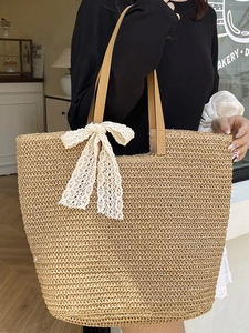 Bohemian hand-woven straw tote bag with white lace bow decoration and slim brown handles