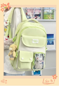 Detail view of a white and green kawaii backpack with a clear window and plush bear charm