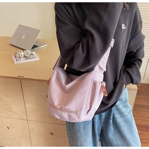 Detail of light purple canvas crossbody bag with letter embroidery and contrast drawstring