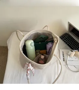 Detail view of cream tote bag interior showing spacious capacity for daily essentials