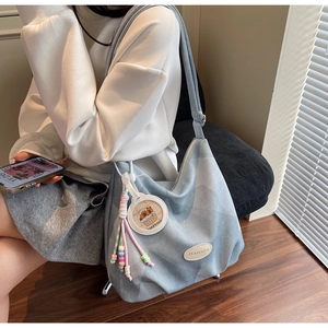 Detalle del bolso tote con colgante Capybara y etiqueta de logo Banatu en cuero