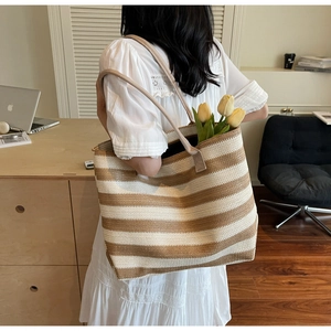 Close-up of a large striped woven tote bag with tulip details for summer beach travel
