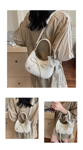 Détail du sac croissant blanc avec décoration de nœud et breloque en perles