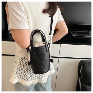 Vue arrière d'un sac seau noir en cuir grainé avec cordon de serrage porté par un mannequin