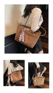 Detail of brown litchi pattern tote bag featuring a decorative red polka dot silk scarf