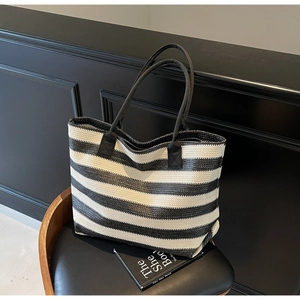Detail of the woven texture and black-and-white stripes on a summer tote bag
