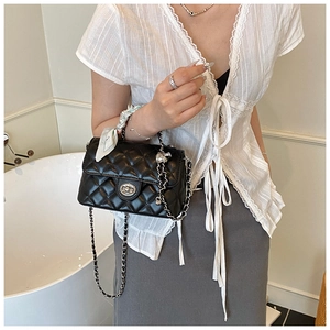 Quilted black crossbody bag detail with silver turn-lock and scarf-wrapped handle