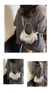Détail du sac croissant argenté avec nœud et pendentif élégant en dentelle de perles