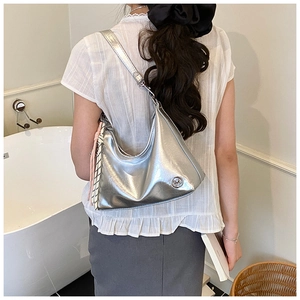 Detailed view of silver metallic crescent hobo bag with texture and knot charm