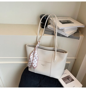 Close-up of cream white lychee pattern tote bag with decorative silk scarf and front pocket