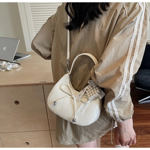 Détails du sac demi-lune blanc orné d'un nœud papillon et d'une perle élégante accrochée