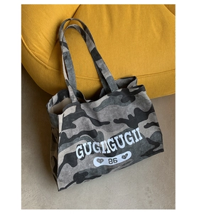 Detail of waterproof camouflage tote bag with letter print on artistic yellow background