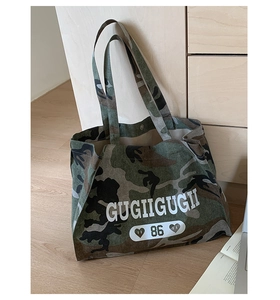 Detail of camouflage canvas tote bag featuring white GUGIIGUGII letter print and 86 logo