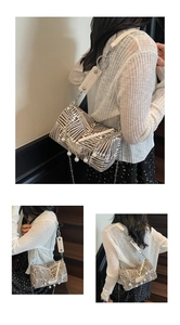 Detailed shot of striped tote bag with pearl charms and metallic chain accents