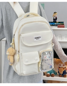 Detail view of cream canvas backpack featuring a transparent pocket with plush toys
