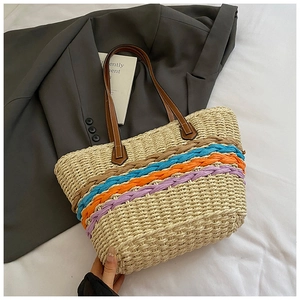 Detailed close-up of woven paper straw tote with vibrant colorful stripes and leather straps