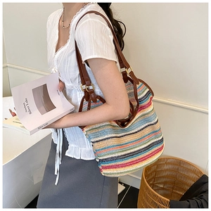 Detail of colorful woven tote bag with brown leather strap and golden metal buckle