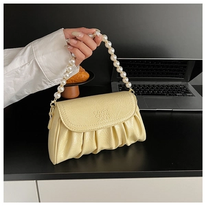 Détail du sac nuage plissé jaune crème avec une bandoulière en grosses perles blanches