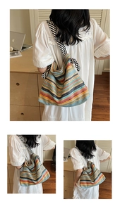 Detail of colorful striped straw tote bag with knotted shoulder straps for summer