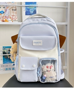 Detail of cute student backpack with transparent window and plush bear pendant