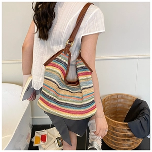 Detail of colorful woven hobo bag with rainbow stripes and brown leather shoulder strap