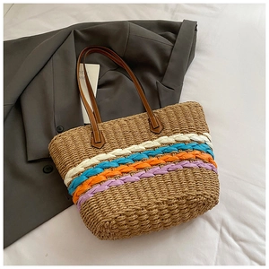 Detailed shot of handmade straw tote bag with colorful woven stripes and leather straps