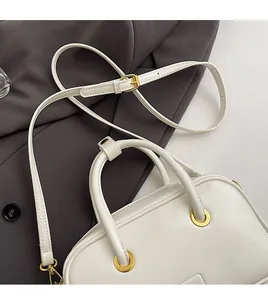 Detail of adjustable white leather shoulder strap and premium gold metal buckle