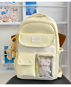 Detail view of cream and white school backpack with transparent window and plush charms