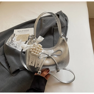 Détail du sac demi-lune argenté métallisé avec nœud et breloque en perles