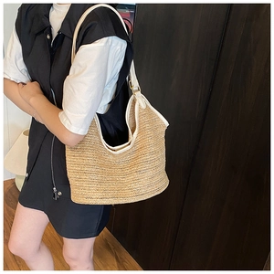 Close-up of handwoven straw tote bag texture with premium cream faux leather straps