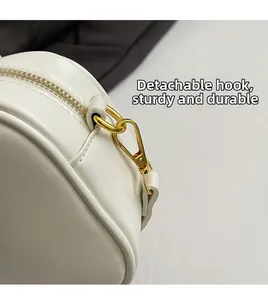 Close-up of durable golden metal hook and zip detail on the white leather bag