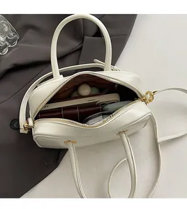 Interior view showing spacious compartments and brown lining of the cream shoulder bag