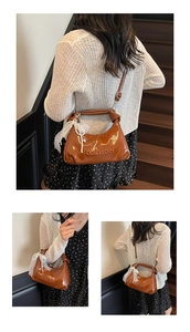 Detailed shot of brown glossy leather bag with fashion embossed logo and lace chain