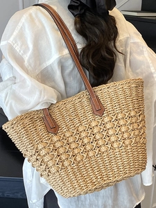 Handwoven straw tote bag with brown leather straps for a casual summer vacation style