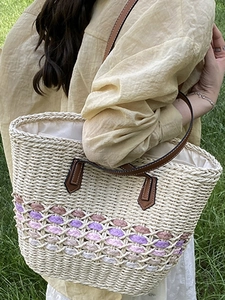 Handmade woven straw tote bag with purple gradient accents and brown leather handles