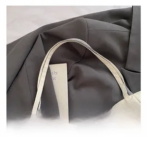 Macro view of canvas tote handle featuring stylish black and white striped webbing detail