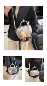 Detail of silver metallic handbag with plush teddy bear charm and adjustable strap