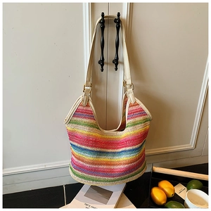 Detail of colorful rainbow woven beach tote with white leather handles and gold buckles