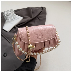 Détail du sac bandoulière plissé rose avec poignée en perles et texture cuir brillant