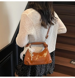 Detail of oil wax leather handbag with fashion logo and lace pearl charm