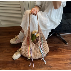 Detailed macro view of beige hollow knit tote bag with vibrant colorful tassels