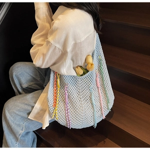 Detailed close-up of light blue crochet tote bag with colorful spiral rope ornaments