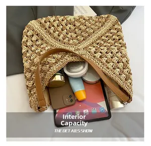 Macro view of the large capacity interior of a woven straw tote bag with travel essentials