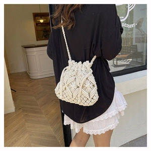Detailed shot of beige woven bucket bag with intricate bohemian pattern and drawstring
